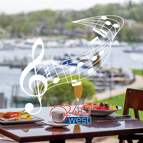 A table with plates of food overlooks a waterfront. Musical notes are superimposed. The logo 