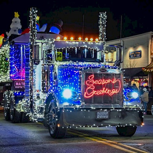 A decorated Christmas parade truck with lights and a 