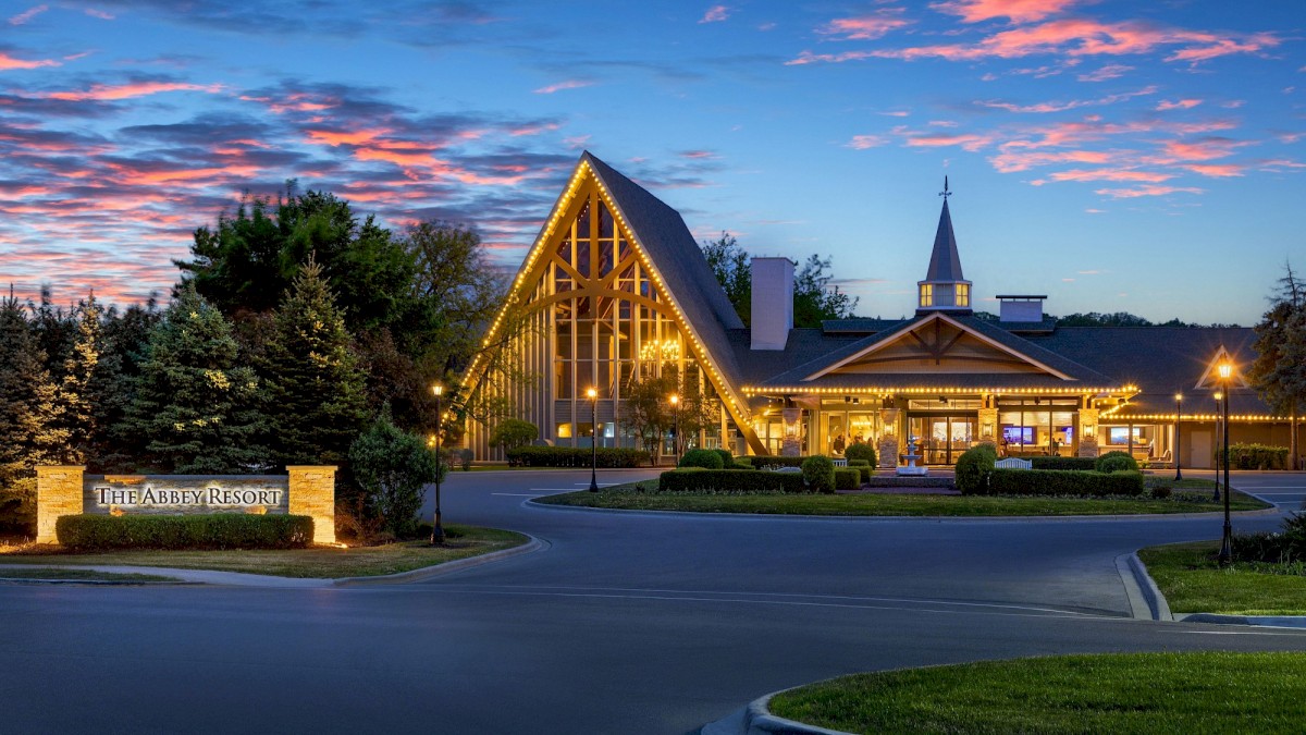 A beautiful building at dusk with warm lights, a sign reading 